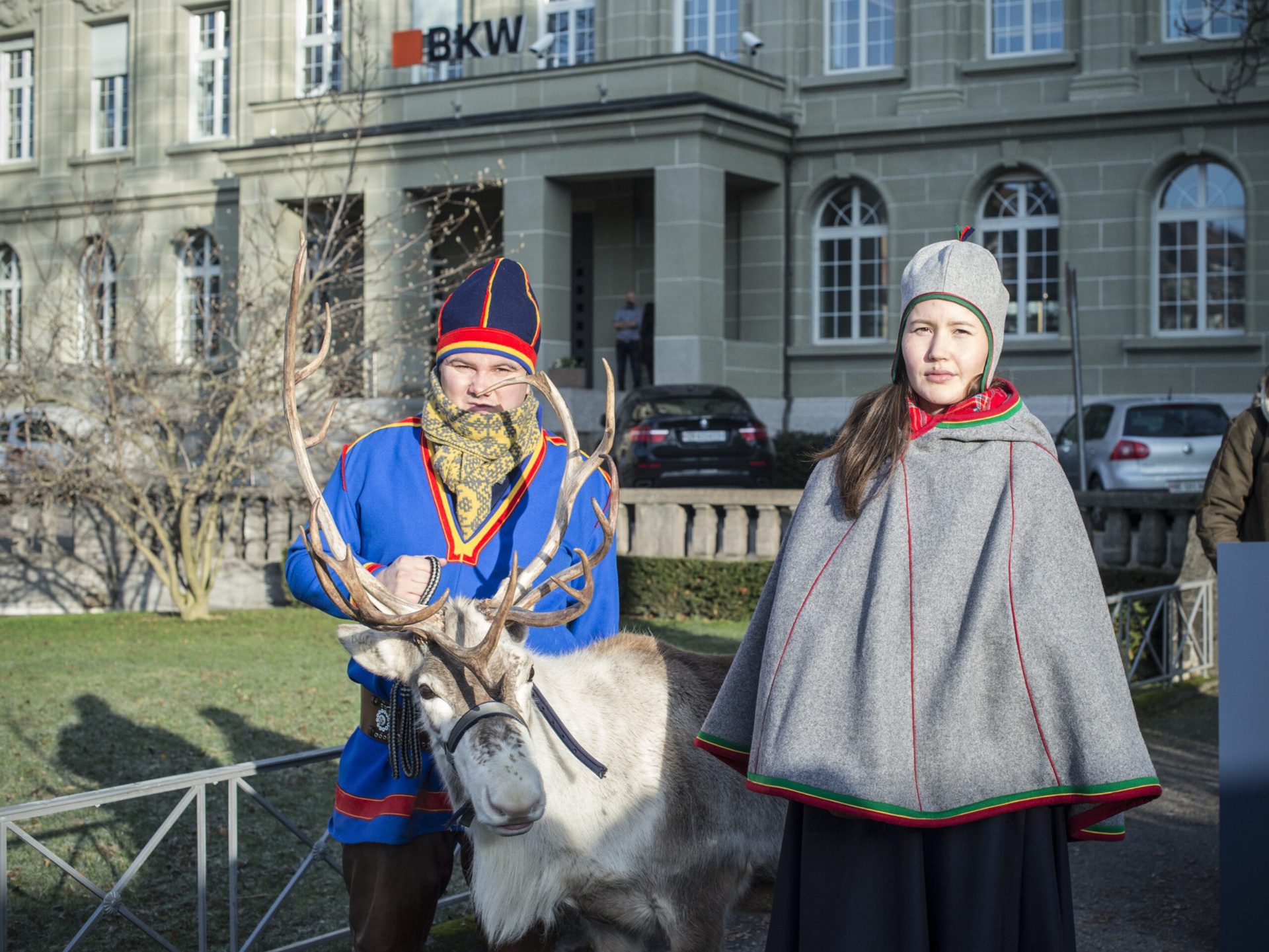 Zwei Sami stehen mit einem Rentier vor dem BKW-Sitz in Bern.
