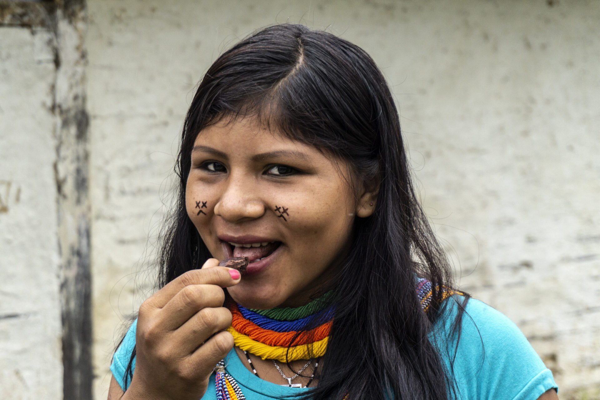 Une fille Yanomami mange un morceau de chocolat